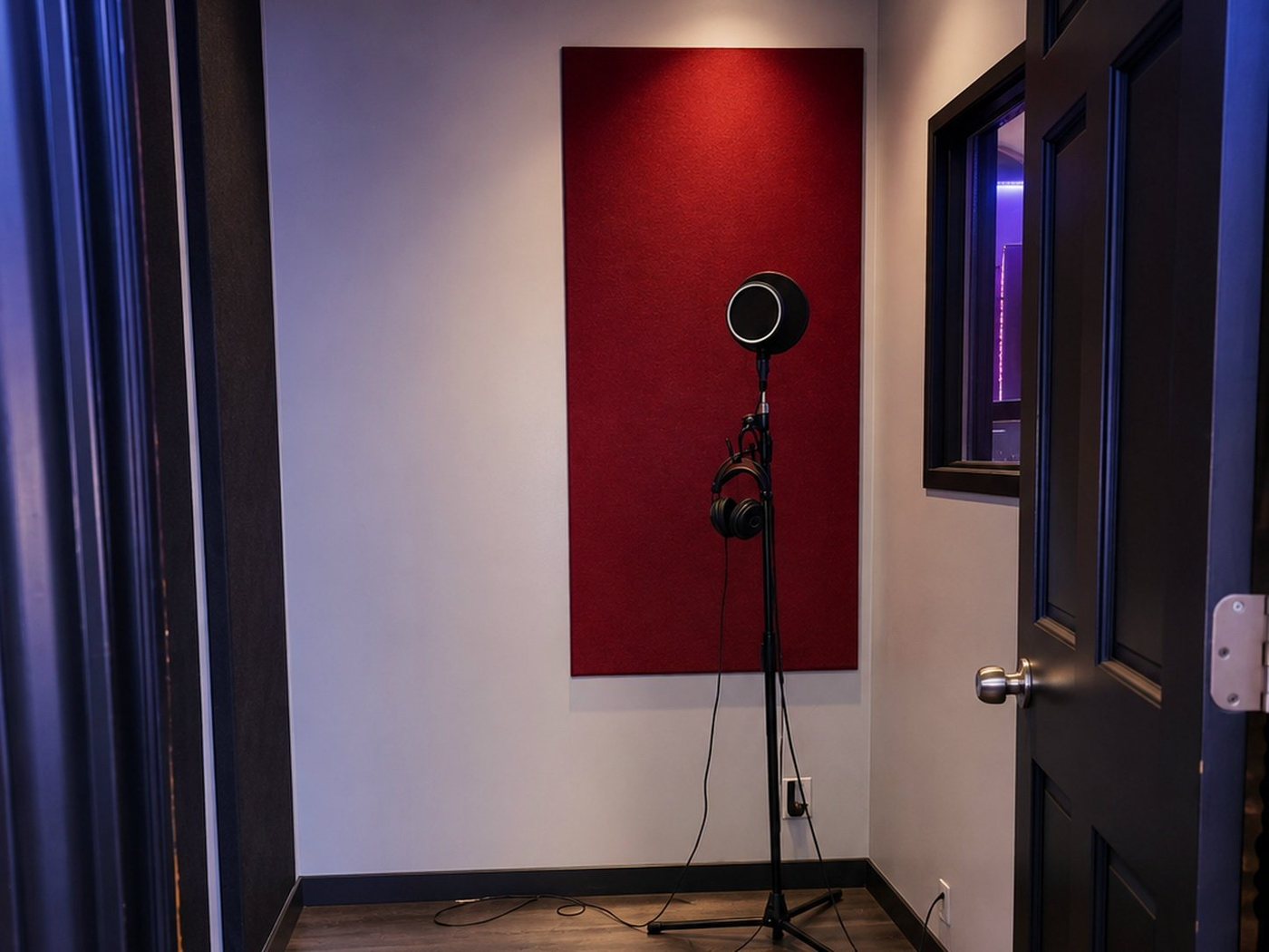 A Room vocal booth with microphone, headphones and a red acoustic panel